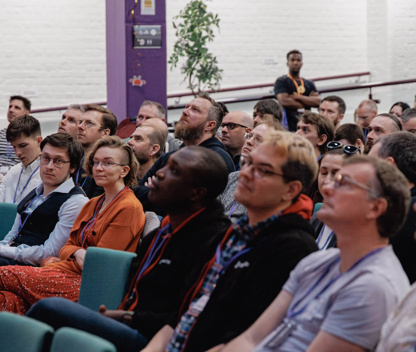 An audience at nor(DEV): con, gaze fixed on the speaker.